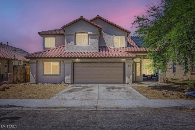 5502 Cinnamon Ave, Las Vegas, NV 89122 - mediterranean / spanish house featuring a tiled roof, driveway, stucco siding, and an attached garage