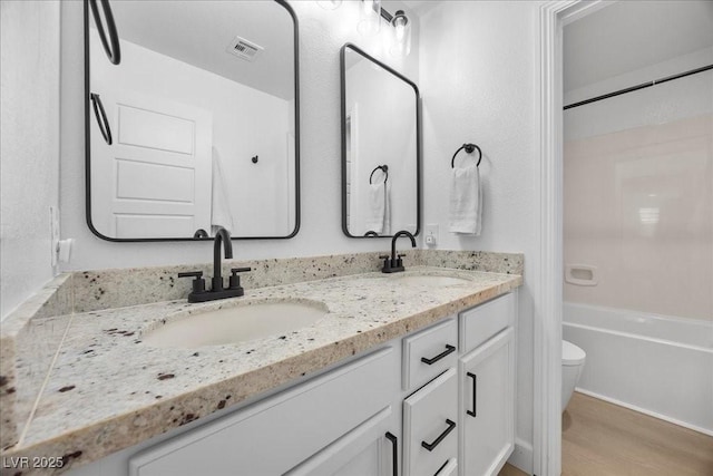 10470 Dove Meadow Way, Las Vegas, NV 89135 - bathroom featuring toilet, double vanity, wood finished floors, and bathing tub / shower combination