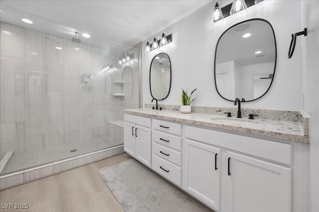 10470 Dove Meadow Way, Las Vegas, NV 89135 - bathroom with double vanity, a tile shower, wood finished floors, and recessed lighting