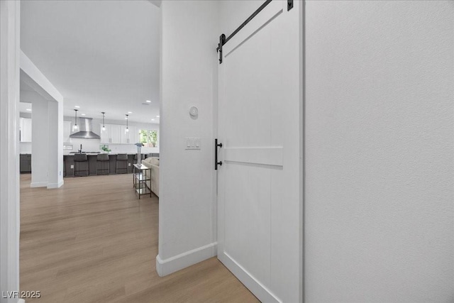 10470 Dove Meadow Way, Las Vegas, NV 89135 - hall with a barn door, light wood-style flooring, and baseboards