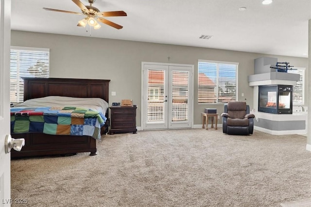 7310 Heggie Ave, Las Vegas, NV 89131 - carpeted bedroom with access to exterior, baseboards, a multi sided fireplace, a ceiling fan, and recessed lighting