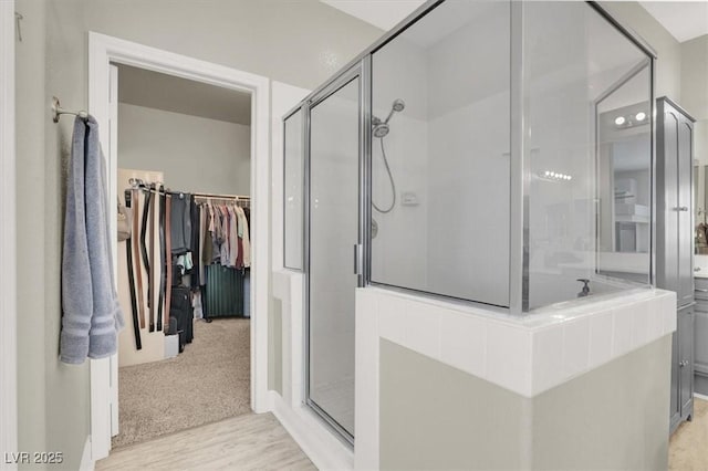 7310 Heggie Ave, Las Vegas, NV 89131 - full bath with a shower stall, a spacious closet, and wood finished floors
