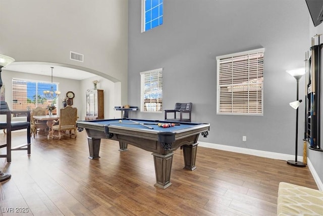 7310 Heggie Ave, Las Vegas, NV 89131 - rec room featuring wood finished floors, arched walkways, a high ceiling, healthy amount of natural light, and baseboards