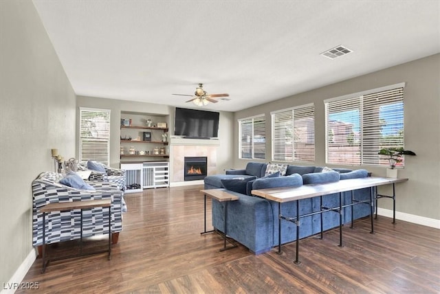 7310 Heggie Ave, Las Vegas, NV 89131 - living room with wood finished floors, ceiling fan, a tile fireplace, and baseboards