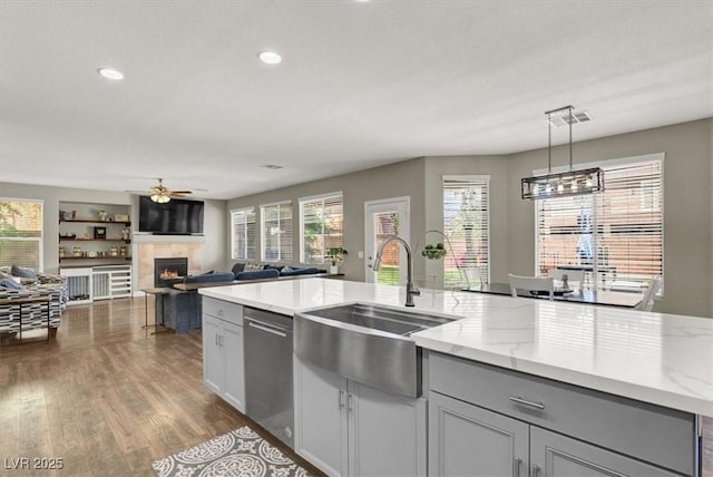 7310 Heggie Ave, Las Vegas, NV 89131 - kitchen featuring a sink, stainless steel dishwasher, a fireplace, ceiling fan, and dark wood finished floors