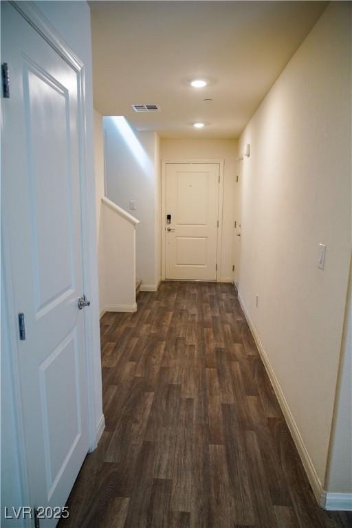 corridor with dark wood-type flooring, baseboards, and recessed lighting