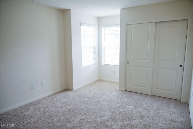 unfurnished bedroom with carpet floors, baseboards, and a closet