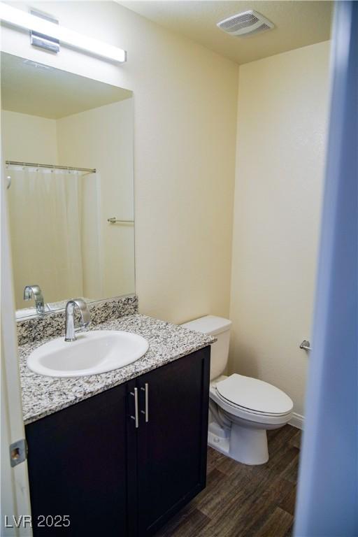 full bath with wood finished floors, vanity, and toilet