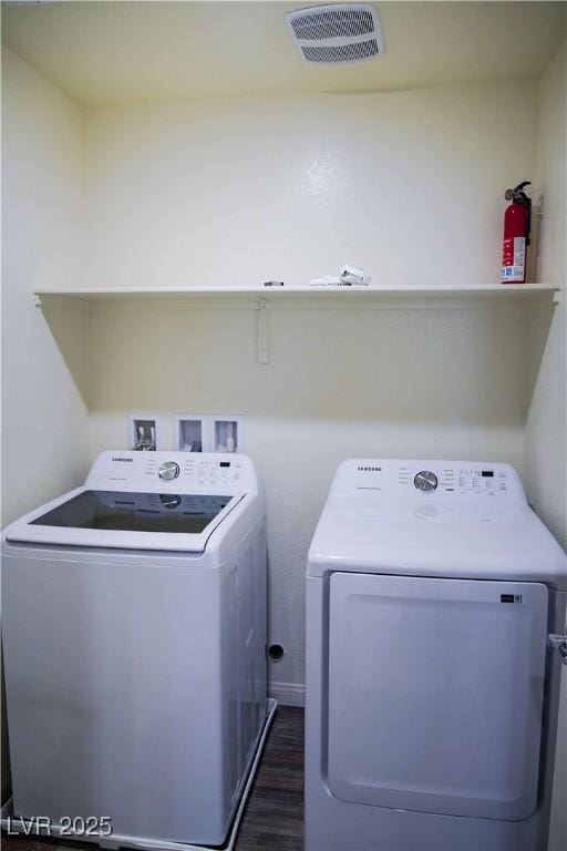washroom with washer and clothes dryer and dark wood-style floors