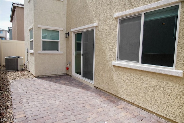 view of patio / terrace with central air condition unit and fence