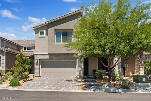 10954 Free Flow Pl, Las Vegas, NV 89138 - view of front facade featuring an attached garage, stone siding, stucco siding, and decorative driveway