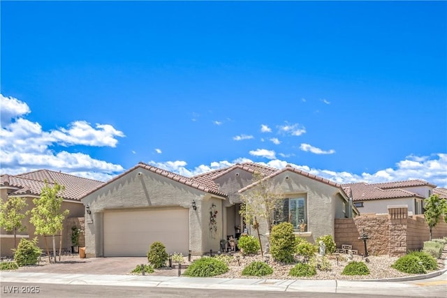 8269 Skye Peak St, Las Vegas, NV 89166 - mediterranean / spanish home with stucco siding, an attached garage, a tiled roof, driveway, and fence