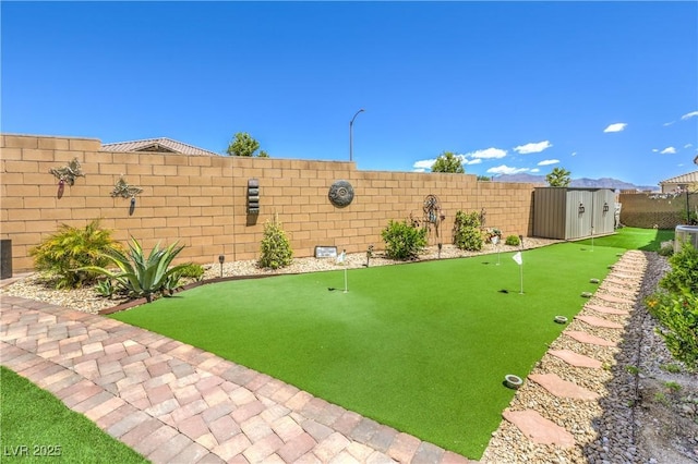 8269 Skye Peak St, Las Vegas, NV 89166 - fenced backyard featuring a putting green, a shed, and an outdoor structure