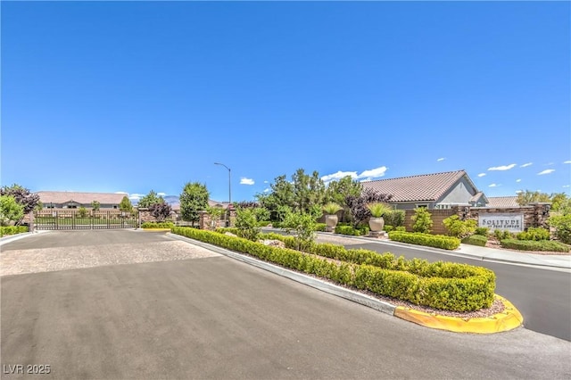 8269 Skye Peak St, Las Vegas, NV 89166 - view of asphalt street with street lights, curbs, and a gated entry