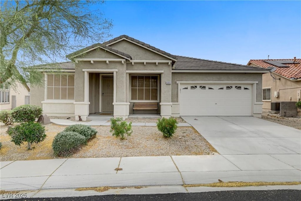 view of front of house with a garage, stucco siding, concrete driveway, and a tiled roof
