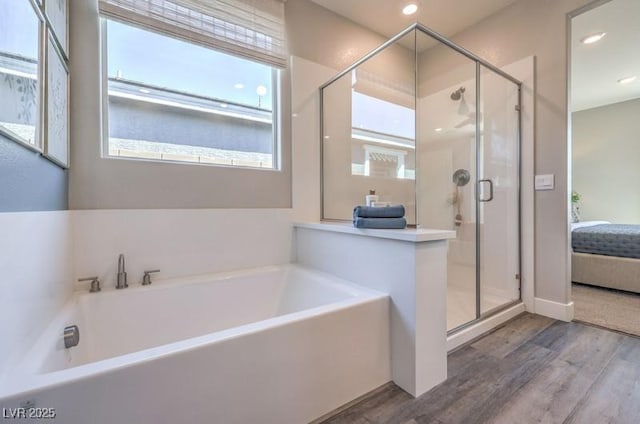 1220 Eva Creek Dr Unit 35, North Las Vegas, NV 89084 - bathroom featuring wood finished floors, ensuite bath, a garden tub, a shower stall, and recessed lighting