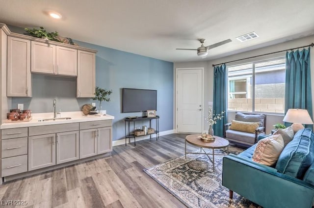 1220 Eva Creek Dr Unit 35, North Las Vegas, NV 89084 - living room featuring light wood-type flooring, baseboards, and a ceiling fan