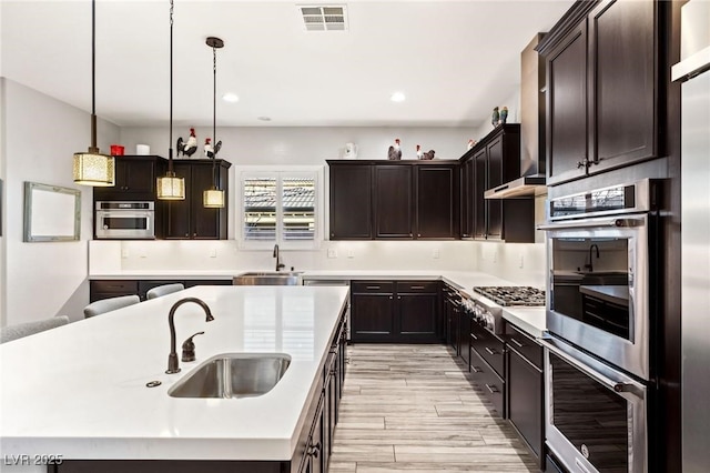 352 Dandelion Brook Ct, Las Vegas, NV 89148 - kitchen with a sink, stainless steel appliances, light countertops, light wood-type flooring, and recessed lighting