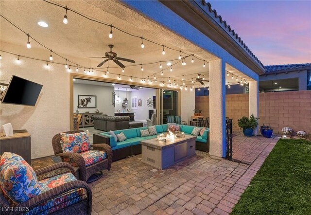 352 Dandelion Brook Ct, Las Vegas, NV 89148 - patio terrace at dusk featuring an outdoor living space with a fire pit, a ceiling fan, and fence