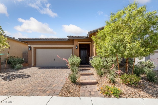 485 Pebble Run Ave, Henderson, NV 89011 - view of front of home with a garage, stucco siding, a tile roof, and decorative driveway
