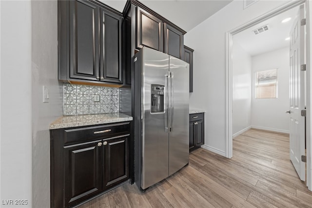 485 Pebble Run Ave, Henderson, NV 89011 - kitchen with stainless steel fridge, light wood-type flooring, decorative backsplash, baseboards, and light stone counters