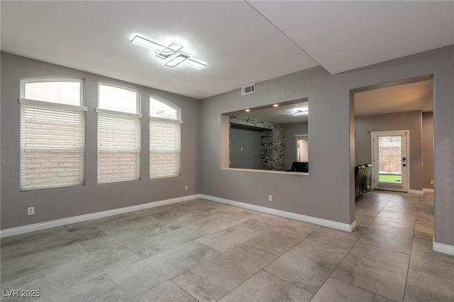 unfurnished room with baseboards and light tile patterned flooring