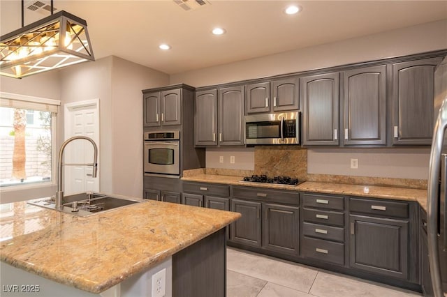kitchen with stainless steel appliances, a sink, recessed lighting, light stone countertops, and light tile patterned floors