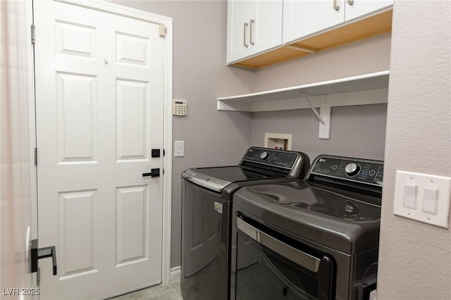 washroom featuring washer and clothes dryer and cabinet space