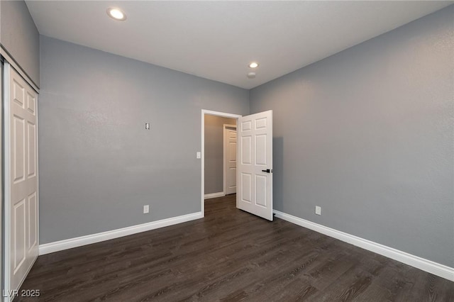 unfurnished room with baseboards, dark wood-type flooring, and recessed lighting