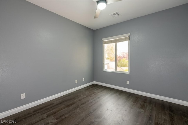 empty room featuring dark wood-style floors, baseboards, and a ceiling fan