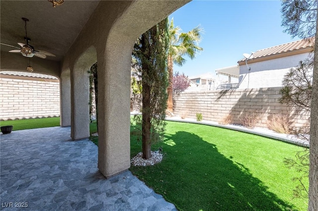 view of yard with a ceiling fan and a patio area