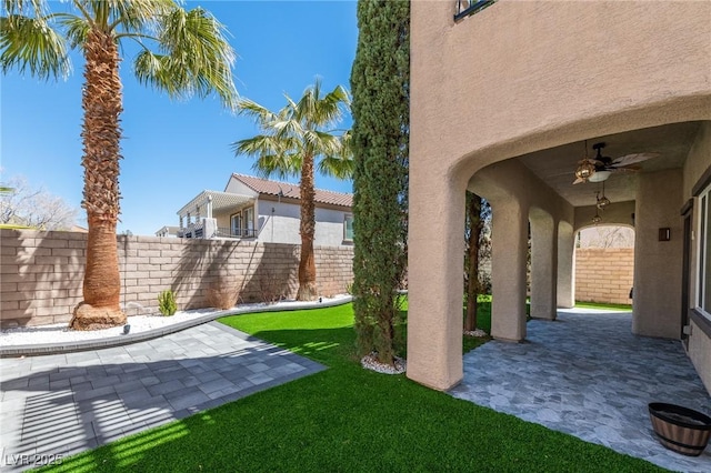 view of yard featuring a patio and ceiling fan