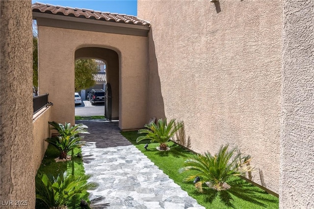 view of exterior entry featuring stucco siding and a tiled roof