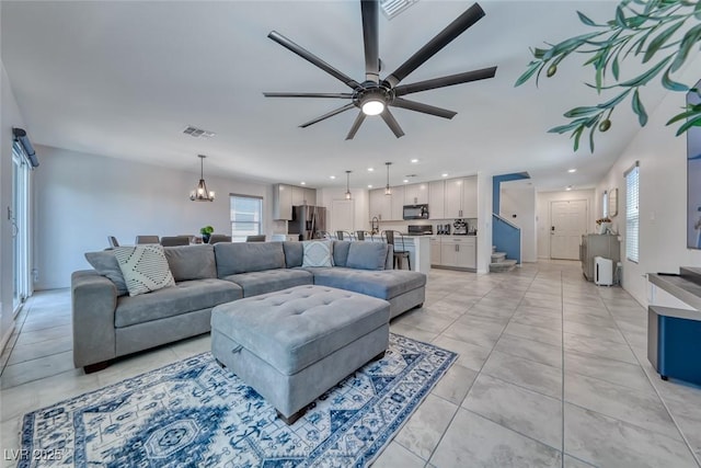 living room featuring a ceiling fan, a chandelier, recessed lighting, and light tile patterned flooring