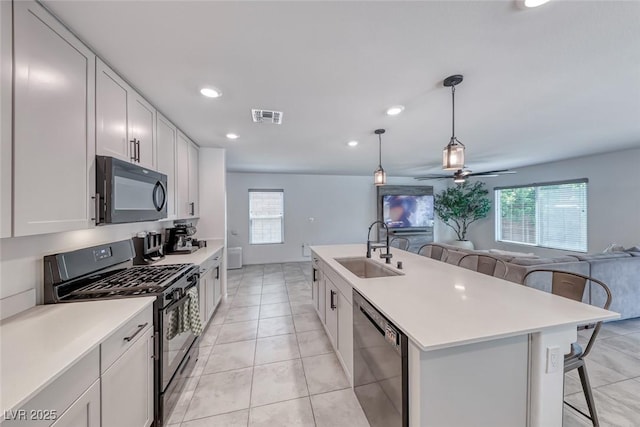 kitchen featuring black appliances, a sink, a breakfast bar area, plenty of natural light, and recessed lighting