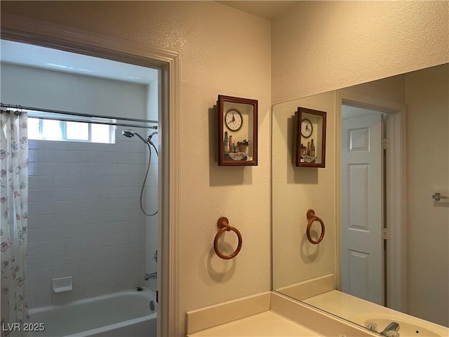 bathroom with shower / bath combination with curtain and a textured wall