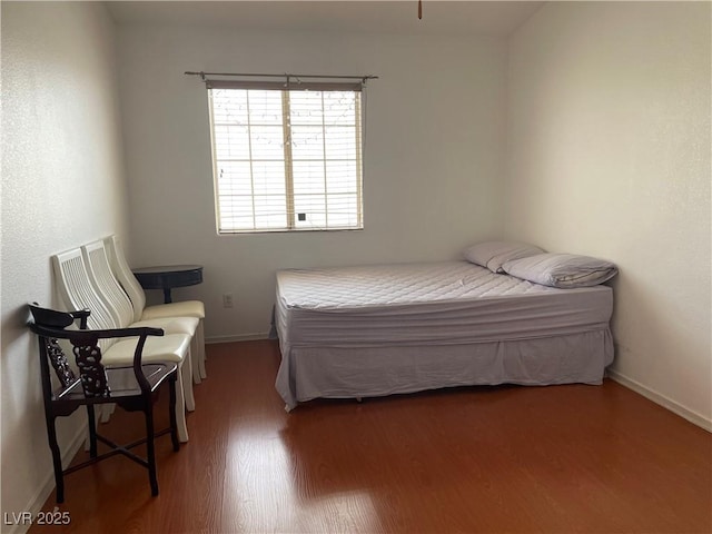bedroom featuring wood finished floors and baseboards