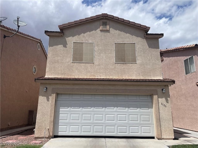 view of front of home with an attached garage, stucco siding, and driveway
