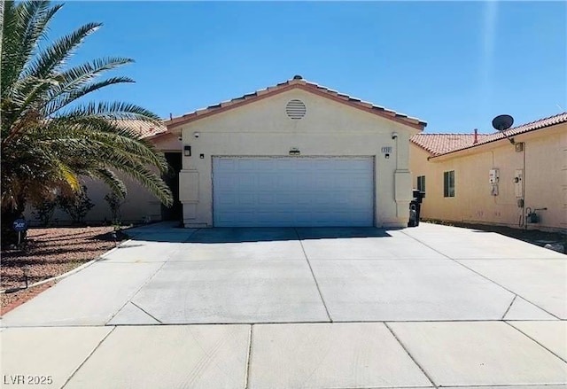 3301 W Colton Ave, North Las Vegas, NV 89032 - mediterranean / spanish-style house with driveway, an attached garage, stucco siding, and a tile roof