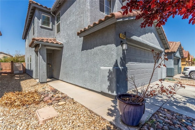 11739 Village Arbor St, Las Vegas, NV 89183 - view of side of home featuring a tile roof, stucco siding, fence, and concrete driveway