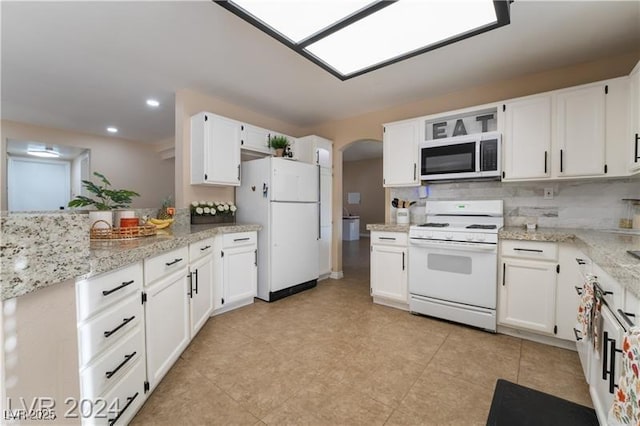 4209 Glass Lantern Dr, North Las Vegas, NV 89032 - kitchen with white appliances, arched walkways, white cabinetry, light stone counters, and recessed lighting
