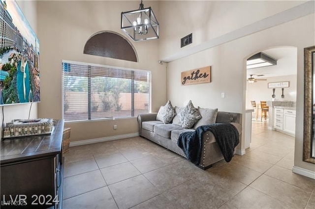4209 Glass Lantern Dr, North Las Vegas, NV 89032 - living area featuring tile patterned floors, arched walkways, a high ceiling, a chandelier, and a ceiling fan