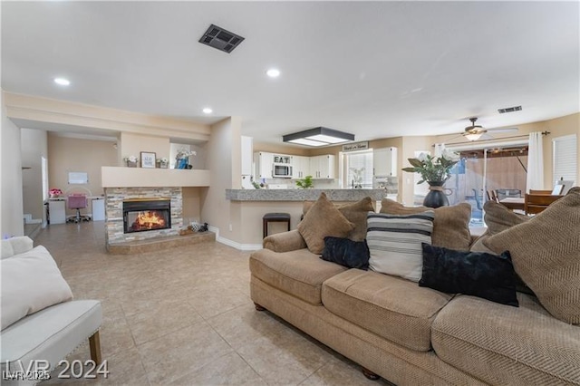 4209 Glass Lantern Dr, North Las Vegas, NV 89032 - living area with baseboards, light tile patterned flooring, ceiling fan, a stone fireplace, and recessed lighting
