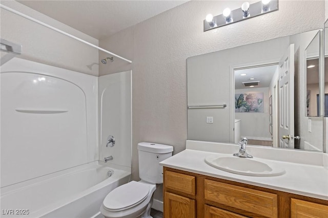 full bathroom with toilet, washtub / shower combination, vanity, and a textured wall