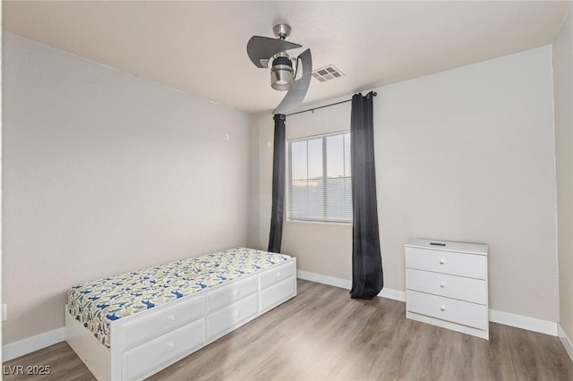 bedroom featuring wood finished floors, baseboards, and ceiling fan