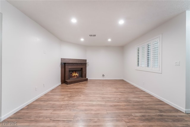 6711 W Charleston Blvd Unit 2, Las Vegas, NV 89146 - unfurnished living room with light wood-style floors, recessed lighting, a fireplace, and baseboards