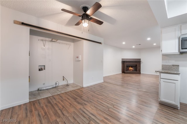 6711 W Charleston Blvd Unit 2, Las Vegas, NV 89146 - unfurnished living room with recessed lighting, light wood finished floors, a ceiling fan, a fireplace, and baseboards