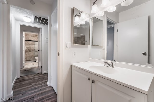 6711 W Charleston Blvd Unit 2, Las Vegas, NV 89146 - bathroom featuring wood finished floors, vanity, toilet, and baseboards
