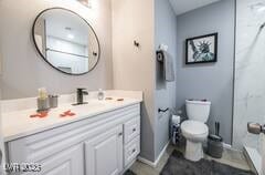 1012 Greystone Dr, Las Vegas, NV 89108 - bathroom with toilet, vanity, baseboards, and a shower