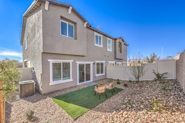 back of property with cooling unit, stucco siding, and a fenced backyard